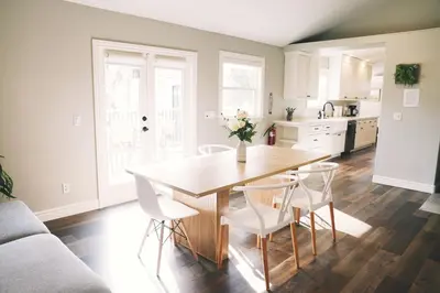 a kitchen with a wooden table and white chairs at A Luxury Yosemite Retreat in Mariposa