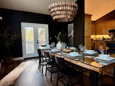 a dining room with a table with chairs and a chandelier at Elegant Blackwood Grove by Casa Oso in Mariposa