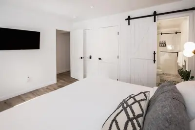 a white bedroom with a bed and a tv at Golden Antler Escape - Minutes to the Beach in Incline Village