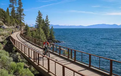 a person riding a bike on a bridge over the water at Mountain Retreat - Lake Tahoe - Incline Village - Private Garage in Incline Village