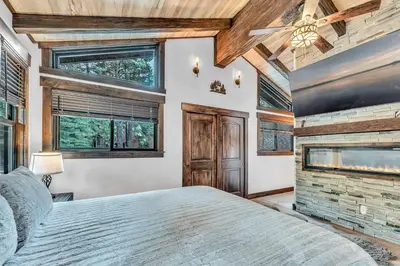 a bedroom with a large bed and a fireplace at Fire & Ice Spacious Retreat with Hot tub and Fireplace in Truckee