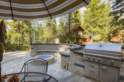 a patio with a grill and an outdoor kitchen at Fire & Ice Spacious Retreat with Hot tub and Fireplace in Truckee