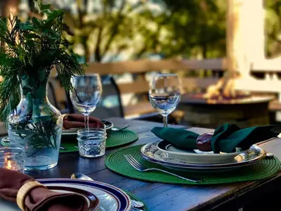 a wooden table with plates and wine glasses on it at Lake Front-Near Yosemite-Pool Table-Private Dock -PML in Groveland