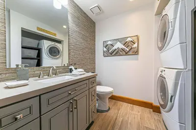 a bathroom with a sink and a washer and dryer at Iron Horse Lodge South 302 by East West Hospitality in Truckee