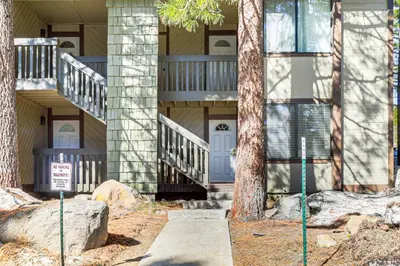 a house with stairs and a sign in front of it at Walk to Shops and Eats Mammoth Lakes Condo with Pool in Mammoth Lakes