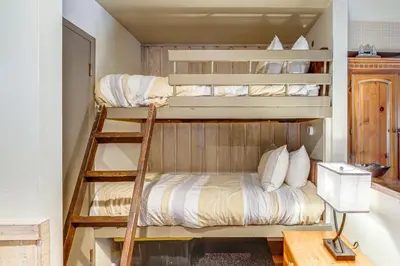 two bunk beds in a small room with a desk at Walk to Shops and Eats Mammoth Lakes Condo with Pool in Mammoth Lakes