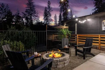 a backyard with a fire pit and chairs and a fence at Modern 2 Bedrm Kids, Dog, Hot Tb, Game Room, 9 min Bass Lake in Oakhurst