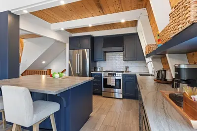 a kitchen with blue cabinets and a counter top at Spacious 5BDR Lake View Home w Hot Tub Close to Slopes Town Beach in Tahoe City