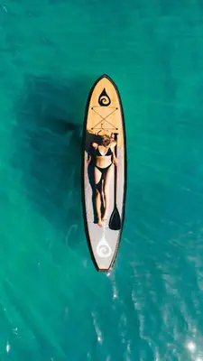 a woman on a paddle board in the water at Spacious 5BDR Lake View Home w Hot Tub Close to Slopes Town Beach in Tahoe City