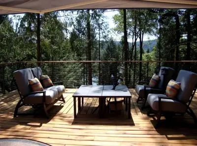 a patio with chairs and a table on a deck at Stunning and Secluded Lakeside Getaway in the Grass Valley of California in Grass Valley