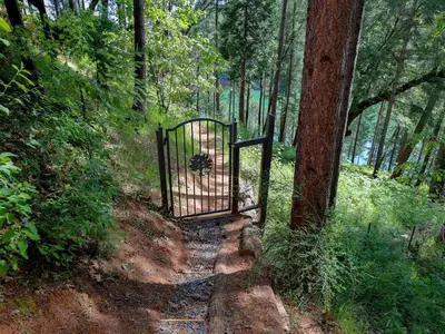 a gate in the middle of a forest at Stunning and Secluded Lakeside Getaway in the Grass Valley of California in Grass Valley