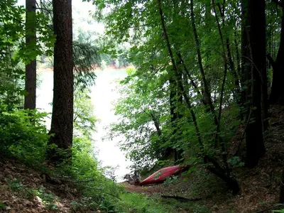 a red kayak in the woods next to a river at Stunning and Secluded Lakeside Getaway in the Grass Valley of California in Grass Valley