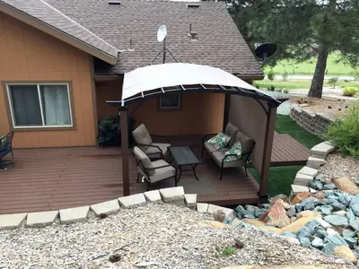 a wooden deck with a gazebo on a house at Luxury Cabin Rental with a Fire Pit in Coulterville, California in Coulterville