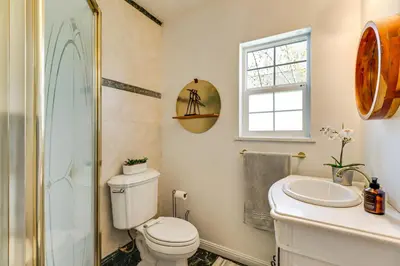 a bathroom with a toilet and a sink and a window at 24 Mi to Slopes! Family Reno Home with Outdoor Oasis in Reno