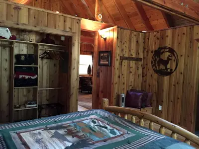 a bedroom with a bed and a wooden wall at Traditional Log Cabin Rental for Couples on the West Shore of Lake Tahoe, California in Tahoe City