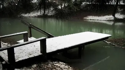 a bench in the water with snow on it at Country Cabin with Spa Hot Tub and Private Deck near Rollins Lake in California in Gold Run