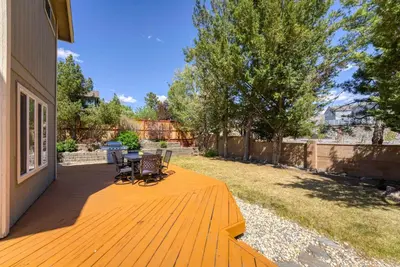 a wooden deck with chairs and a table on it at Cozy 3BR Family Home with Patio & BBQ grill Close to Casinos and Shops in Reno