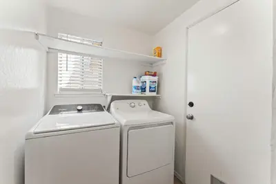a white laundry room with a washer and a window at Cozy 3BR Family Home with Patio & BBQ grill Close to Casinos and Shops in Reno