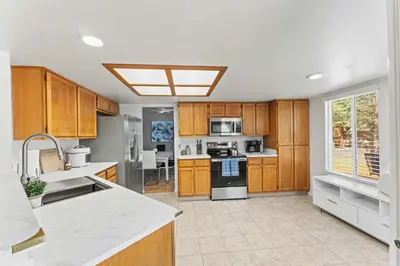a large kitchen with wooden cabinets and appliances at Cozy 3BR Family Home with Patio & BBQ grill Close to Casinos and Shops in Reno