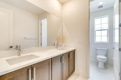 a bathroom with two sinks and a toilet at Pool Paradise Spacious Tracy Home with Yard! in Tracy