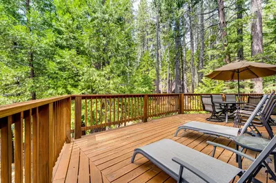 a deck with chairs and tables and an umbrella at Game Room Blue Lake Mountain Retreat in Arnold in Arnold
