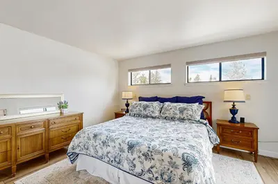 a bedroom with a bed and two windows at Modern Mountain Escape in South Lake Tahoe