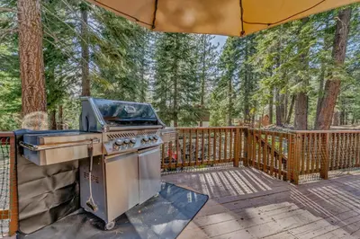 a barbecue grill on a deck with a fence at Spacious Pet-Friendly Truckee Retreat with Hot Tub in Truckee