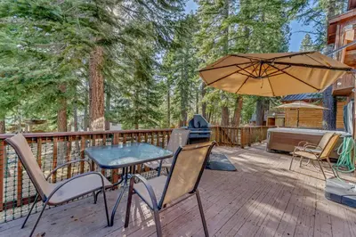 a patio with a table and chairs and an umbrella at Spacious Pet-Friendly Truckee Retreat with Hot Tub in Truckee