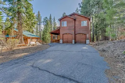 a home in the woods with a driveway at Spacious Pet-Friendly Truckee Retreat with Hot Tub in Truckee