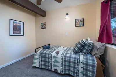 a bedroom with a bed with a blanket and pillows at Yosemite Aviary - Bird's Eye View Awesome Upper Unit in Yosemite West