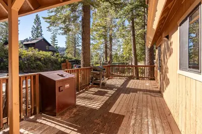 a wooden deck with a grill on the side of a house at Yosemite Aviary and Quail Within Yosemite - 2 Separate Family Units Welcoming Up To 14 Guests in Yosemite West