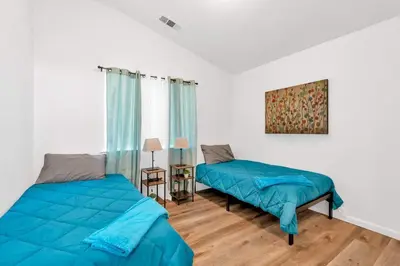 a bedroom with two beds and a table with a lamp at University Pastoral - Family Perfect Close to UCM in Merced