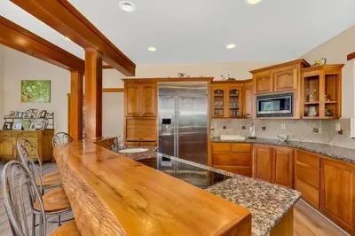 a kitchen with wooden cabinets and a wooden table at Gorgeous 5 BDR Traviloli Mountain Retreat for 10 in Shaver Lake