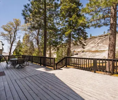 a wooden deck with a table and a bench on it at Granite View Lodge - Minutes from Water in Shaver Lake