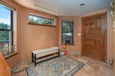 a room with a door and a bench and a rug at Happy Days Retreat with Private Pool in Bass Lake Annex