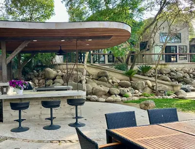 a patio with a table with chairs and an umbrella at River Magic - Riverfront Family Fun & Lux Design in Three Rivers