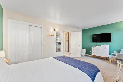 a bedroom with a white bed and a flat screen tv at HNC0617 - Stagecoach Summit Retreat condo in Stateline