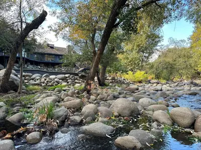 a river with rocks and trees and trees at River Soul – Riverfront Luxury & Stunning Views in Three Rivers