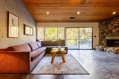 a living room with a couch and a fireplace at River Soul – Riverfront Luxury & Stunning Views in Three Rivers