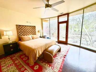 a bedroom with a bed and a large window at Sequoia Arquitectural Wonder with Hot Tub & Views in Three Rivers
