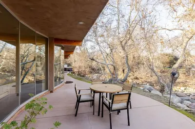 an outdoor patio with a wooden table and chairs at Sequoia Arquitectural Wonder with Hot Tub & Views in Three Rivers