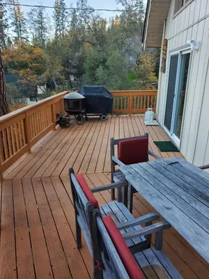 a wooden deck with a picnic table and a grill at Serenity View, Peaceful & Cheerful 3BD Cabin in Groveland