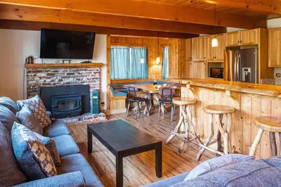 a living room with a couch and a kitchen with a fireplace at Red House - Minutes to Shaver Lake in Shaver Lake