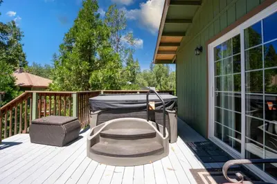 a patio with a grill and a table on a deck at Immersed in Nature Manzanita Cabin with Hot Tub in Oakhurst