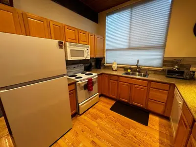 a kitchen with wooden cabinets and a white refrigerator at Spacious Condo walking distance to Hyatt and Beaches in Incline Village