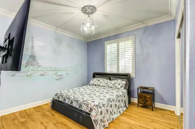a bedroom with a bed and a wall with the eiffel tower at 5 Mi to Dtwn Modesto Family Home with Patio! in Modesto