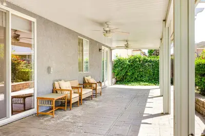 a porch with chairs and a ceiling fan at 5 Mi to Dtwn Modesto Family Home with Patio! in Modesto