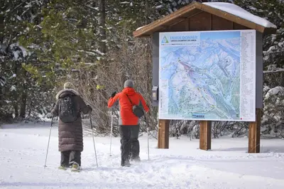 two people standing next to a sign in the snow at Paradise on Pinnacle in Truckee