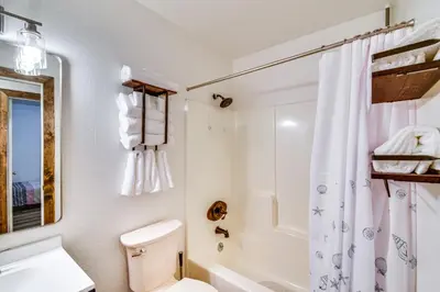 a white bathroom with a toilet and a shower at Sierra Serenity Scenic Mtn Escape with Game Room in Oakhurst
