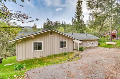 a house with a driveway in front of a garage at Sierra Serenity Scenic Mtn Escape with Game Room in Oakhurst